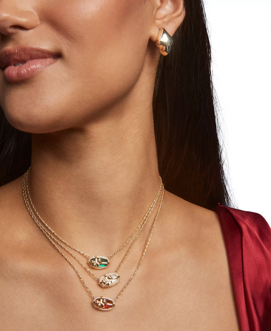 Gold-plated bow pendant necklace on model, oval teal and clear stones on gold chains