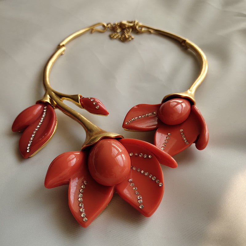 Coral flower resin necklace with gold-tone collar, large petals, and rhinestones