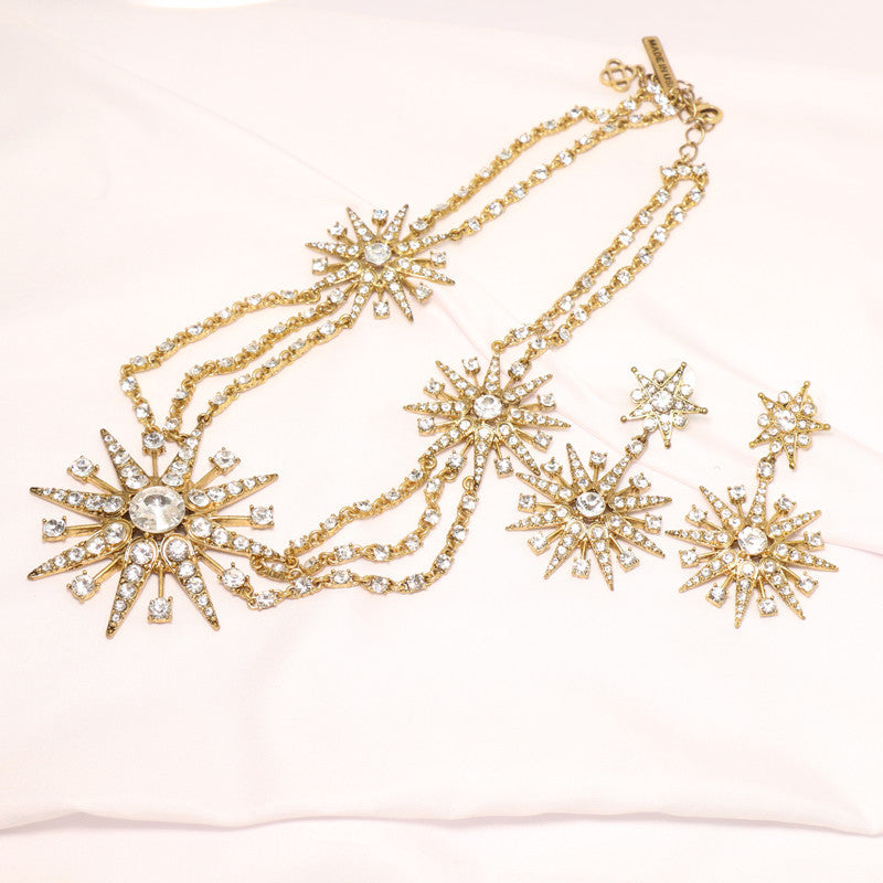 Gold-tone crystal star drop earrings with dangling eight-pointed star charms