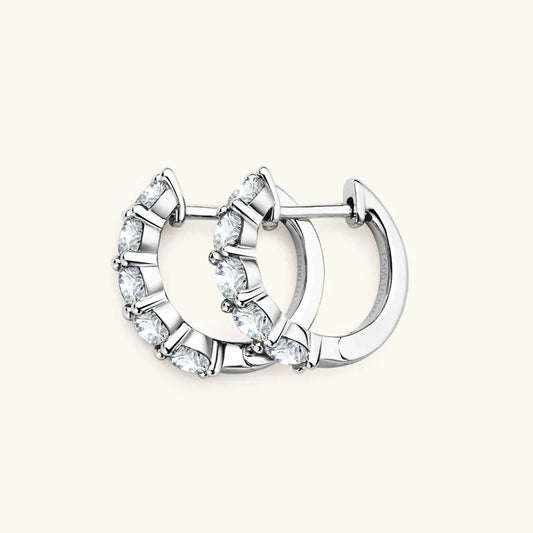 Silver hoop earrings with five round prong-set stones and a hinged clasp back.