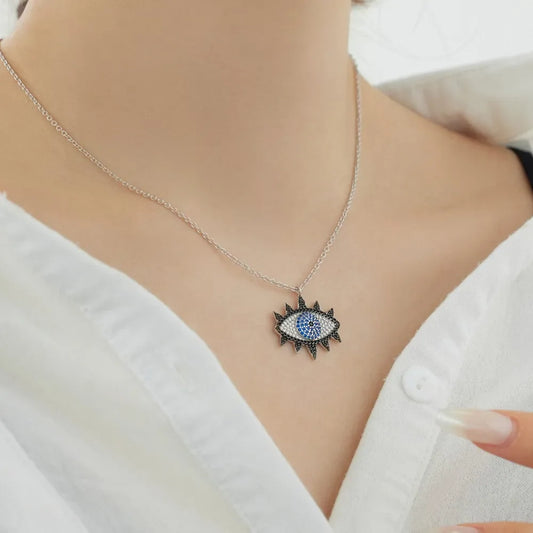 Evil eye pendant necklace on neck: rhodium-plated silver chain with blue CZ eye charm