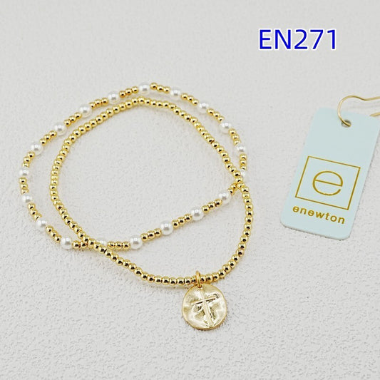 Two gold-tone bead bracelets with white pearls and round disc cross pendant charm
