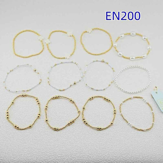 12-piece set bracelets in gold and white pearls, mixed styles laid out