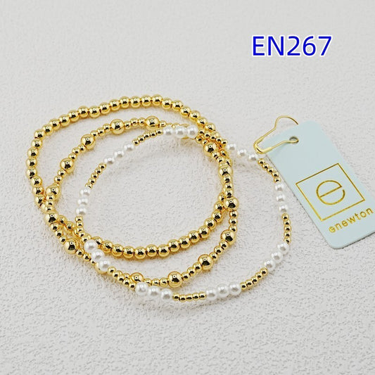 Three beaded bracelets: gold-tone spheres with white pearls, linked in a stack set