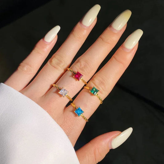 Twisted square CZ solitaire rings with multicolor square stones on fingers, gold tone