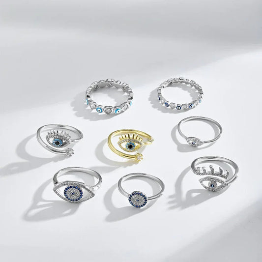 Silver evil eye rings with blue enamel eyes and clear stones, assorted views