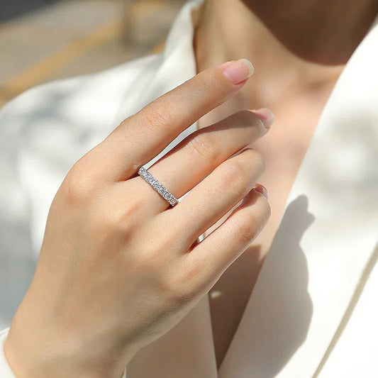 Silver moissanite wedding ring worn on hand, straight row of round stones