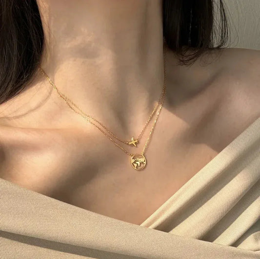 Gold-tone pendant necklace with airplane charm and round world-map globe charm