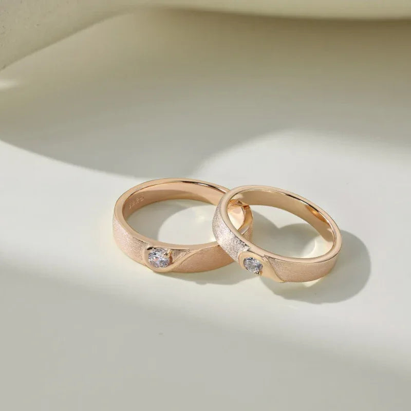 Champagne gold couple wedding rings with clear CZ heart accents on the bands