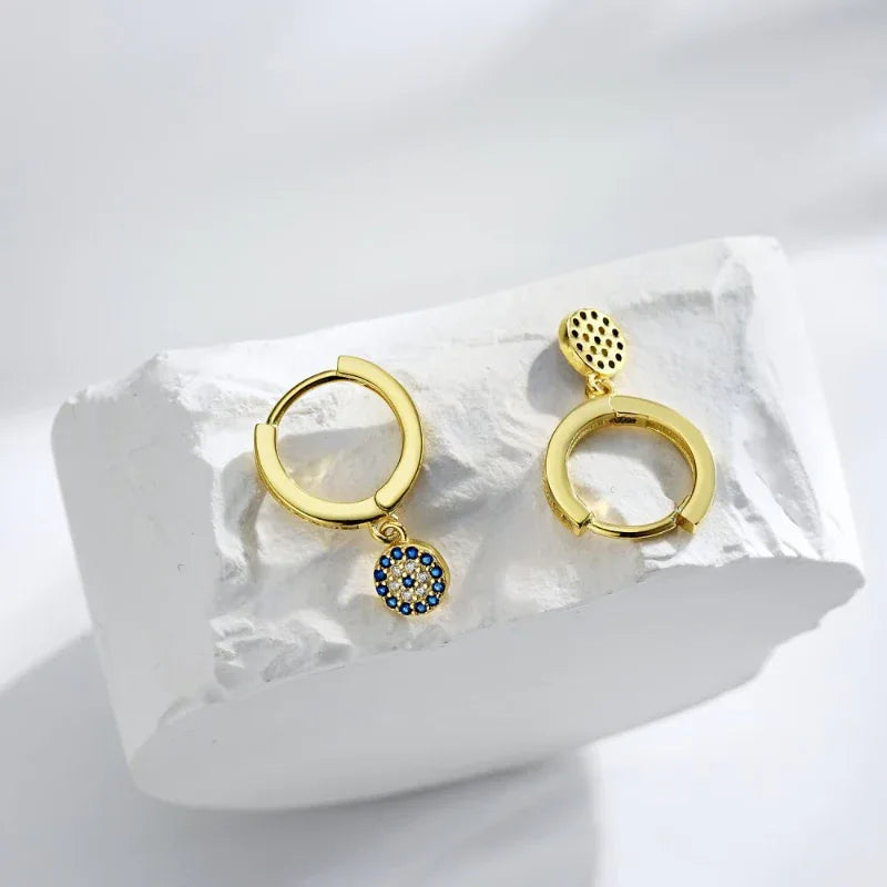 Gold hoop earrings with blue evil eye bead tops and blue disc drop charms
