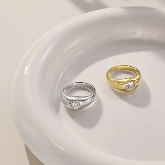 Heart-shaped CZ rings in white gold and gold, each with a bezel-set heart stone