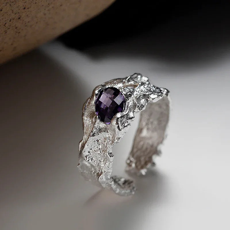 Silver irregular-texture ring with purple oval gemstone, side view