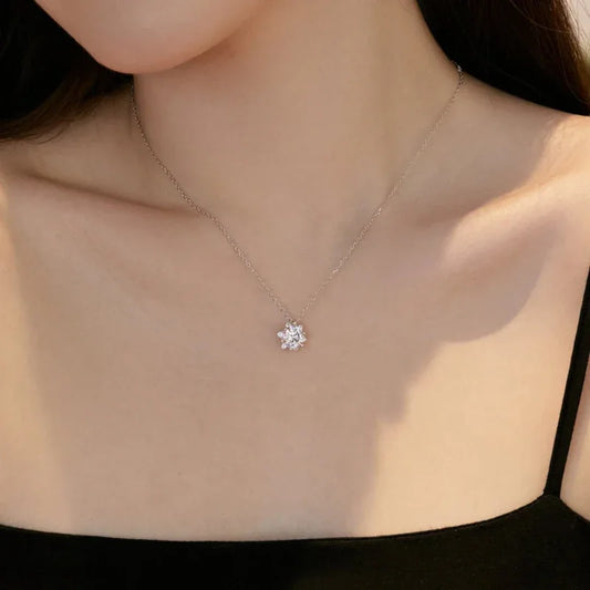 Silver snowflake CZ pendant necklace on collarbone
