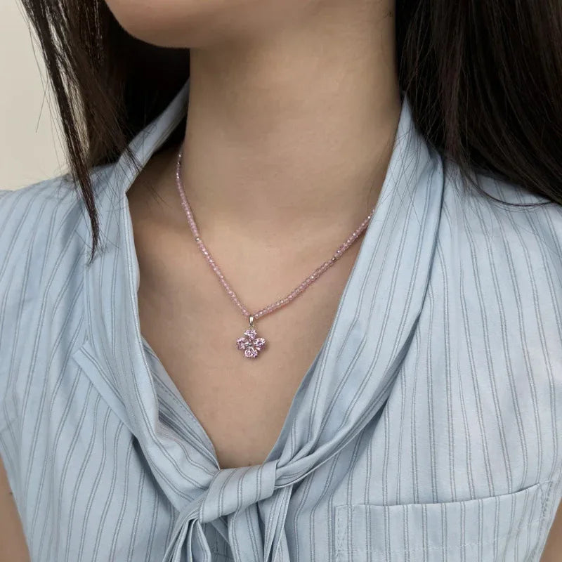 Pink beaded chain necklace with four-leaf clover zirconia pendant, worn at neck