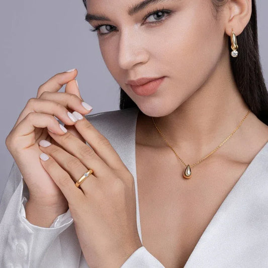 Gold moissanite ring with round gemstone on finger