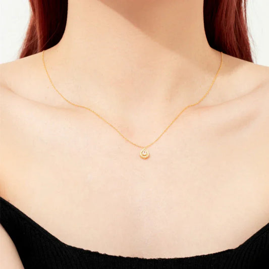 Moissanite solitaire necklace with small round halo pendant on a fine gold chain