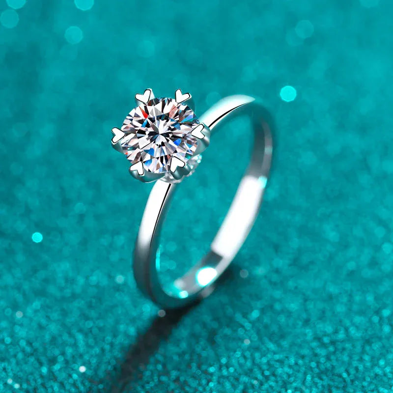 Round moissanite engagement ring with four-prong round center stone on slender band