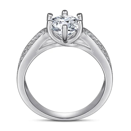 Silver CZ ring with large round center stone, prong setting, and pavé side band