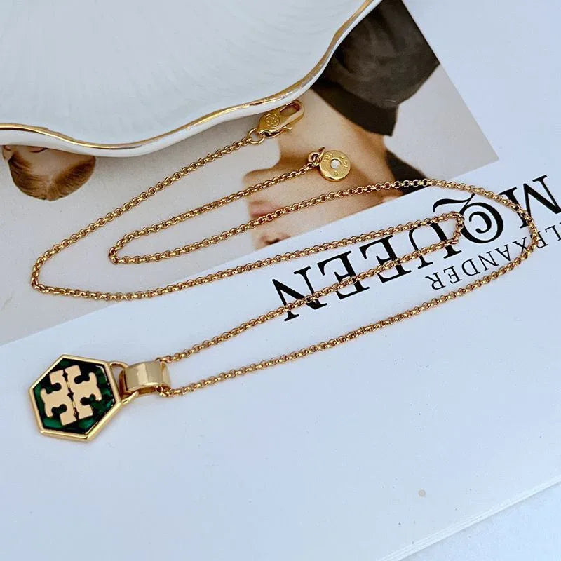 Hexagon logo pendant necklace with green enamel center and gold-tone chain