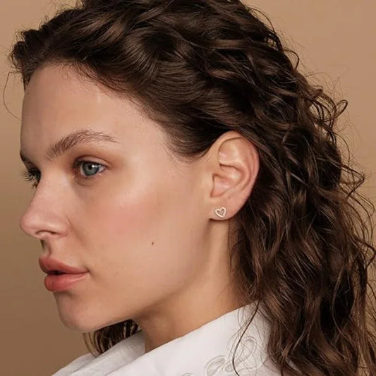 Heart stud earrings on model, silver-tone diamond-look pavé heart