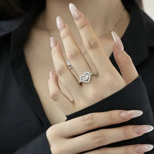 Silver CZ heart ring on finger, featuring a pink heart center with clear side stones
