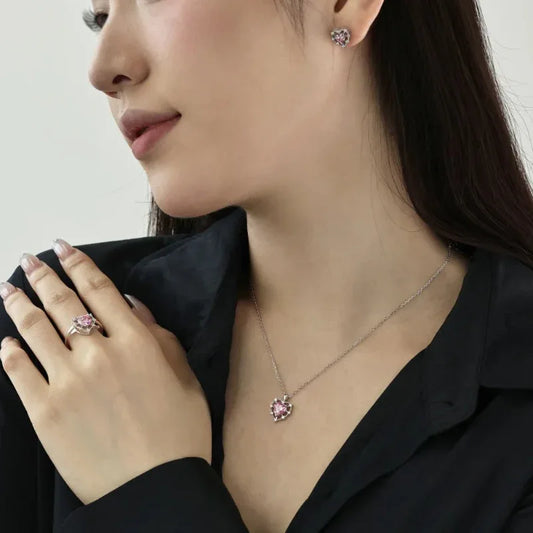 Heart-shaped stud earrings on model ear, pink heart stone with clear pavé halo.