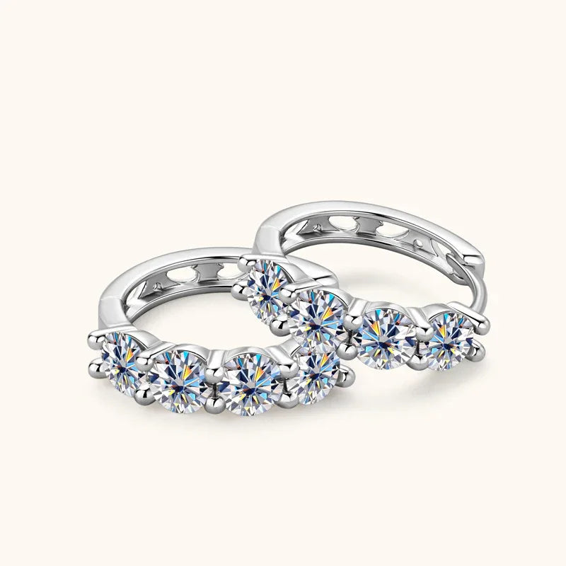 Silver huggie earrings, angled view, featuring four round stones along the hoop