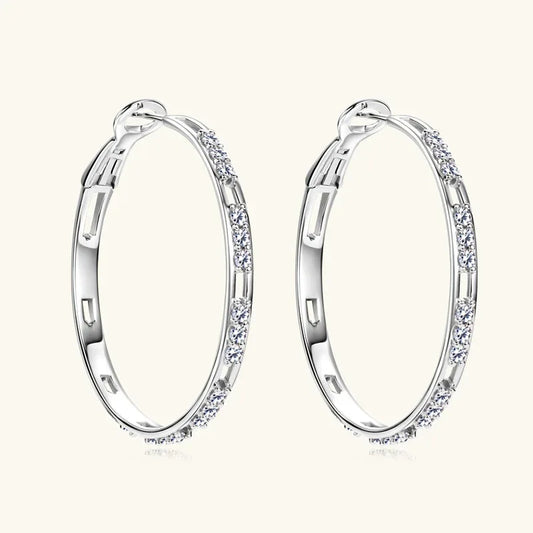 Silver hoop earrings with clear round stones along the outer edge and hinged clasp