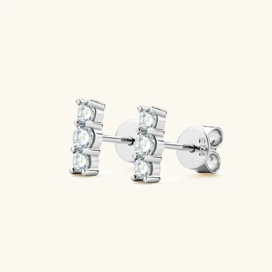 Silver three-stone bar stud earrings with three round stones and a straight post
