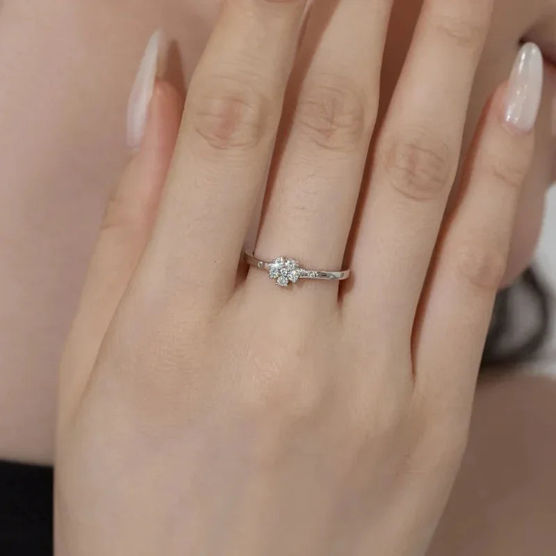 Silver CZ flower ring on finger with round stones set in a band