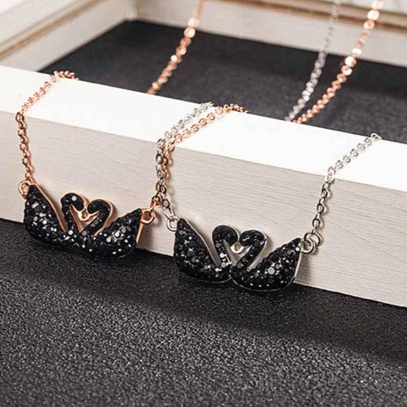 Double swan necklace featuring two black glitter swan pendants on chain, rose and silver