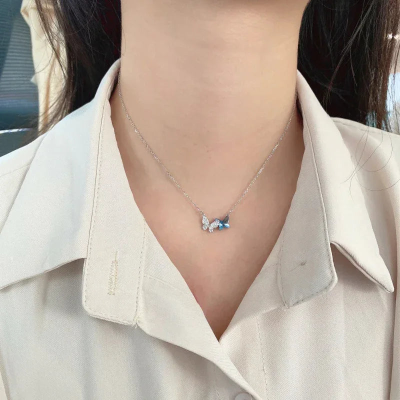 Silver butterfly pendant necklace with butterfly charm and blue CZ center on chain