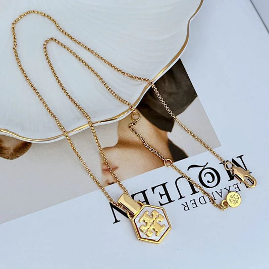 Hexagon logo pendant necklace with light enamel center and gold-tone chain