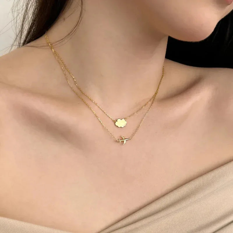 Gold double-layer pendant necklace with cloud charm and airplane charm
