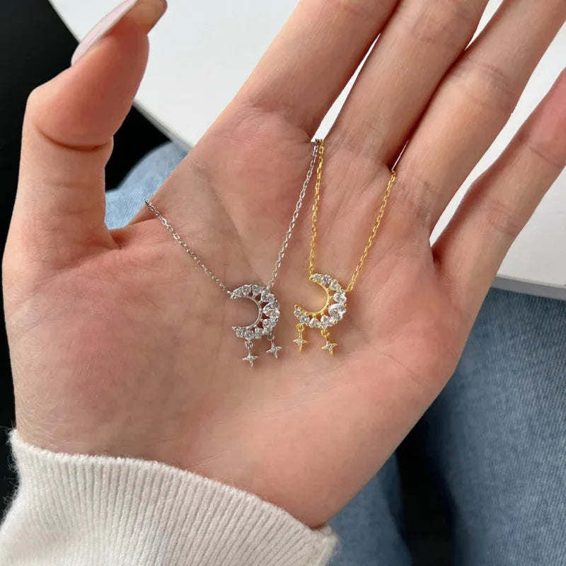 Crescent moon and star CZ pendant necklace with chain, stacked on a hand