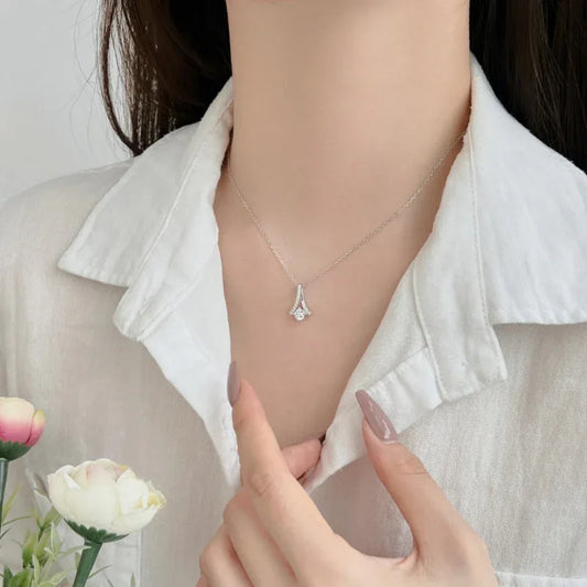 Clavicle necklace with small teardrop CZ charm pendant on thin silver-toned chain
