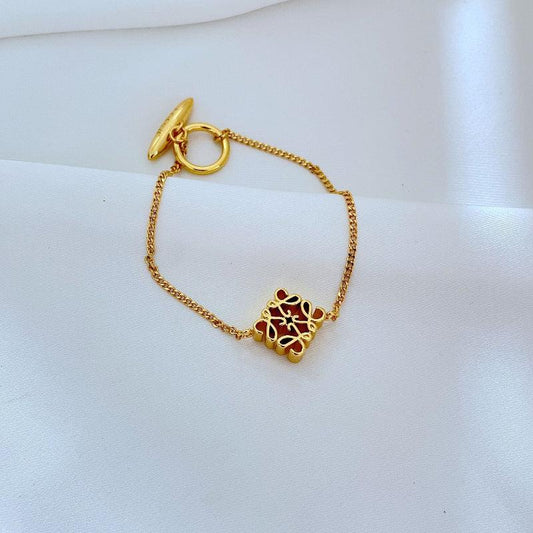Gold chain bracelet with anagram logo charm and ring clasp, small gold link detail