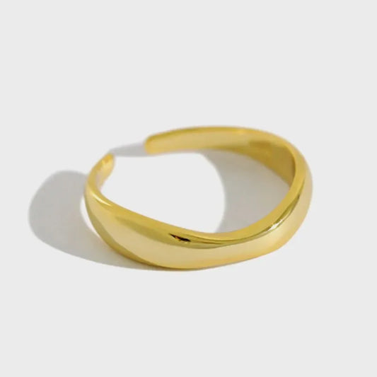 Gold wave ring viewed from above, glossy smooth curved band, minimalist style