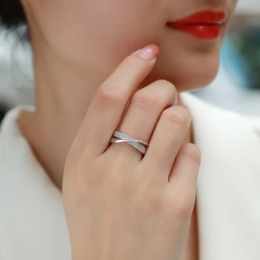 White gold pavé wedding ring on a hand, with thin curved cross-set band