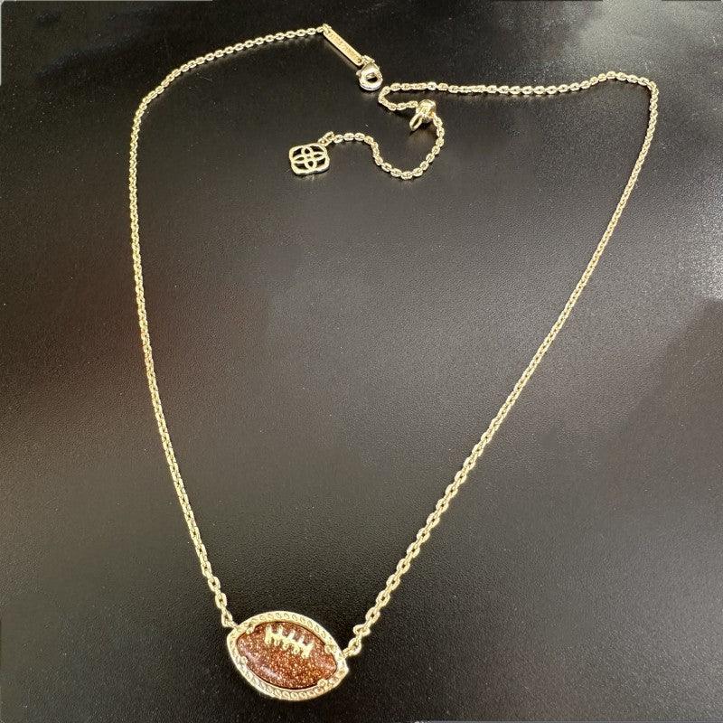 Gold-tone football pendant necklace with brown football charm and small logo charm