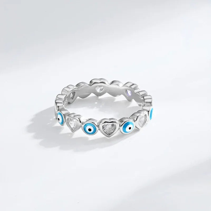 Silver heart evil eye ring with blue enamel eyes and clear stones, side view