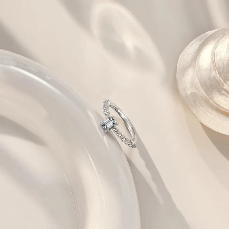 Emerald-cut CZ eternity band ring in rhodium-plated sterling silver with prong-set stones