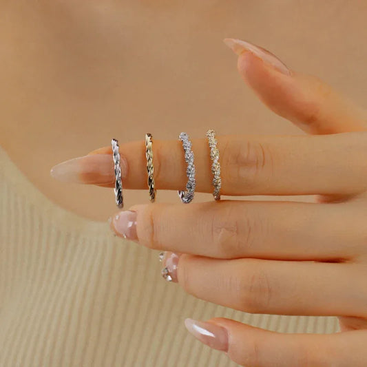 Twisted rope ring on finger in silver-tone metal, polished textured braid