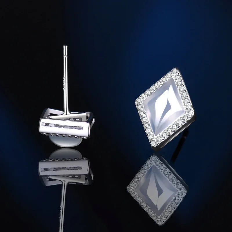 Rhombus stud earrings with white center gem and silver-tone pave border