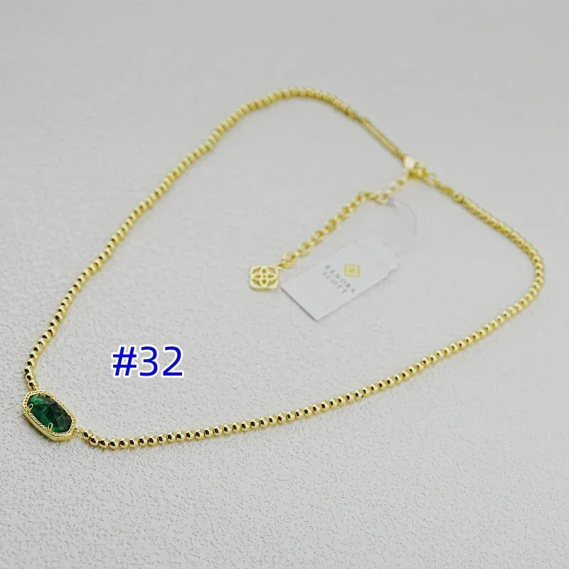 Gold-plated ball chain necklace with dark green teardrop bezel pendant