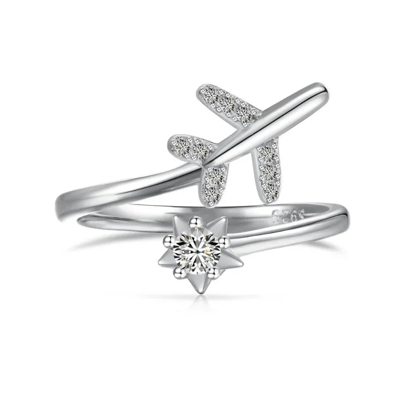 White gold airplane CZ ring with round center stone and star-shaped prongs, adjustable band