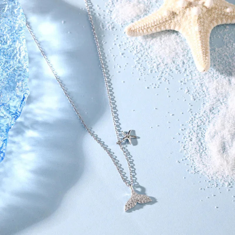 Silver-tone starfish and mermaid tail CZ pendant necklace with chain, close-up