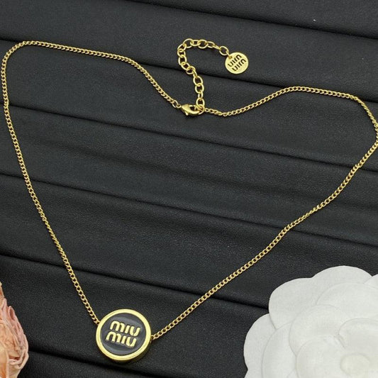 Gold logo enamel necklace with round dark pendant and fine gold chain