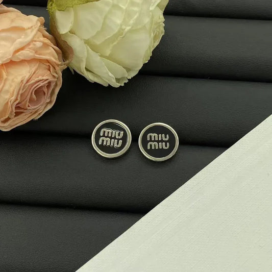 Black enamel stud earrings with round logo discs and silver-tone posts