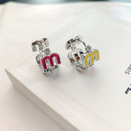 Silver-tone openwork hoop earrings with enamel logo letters in pink and white